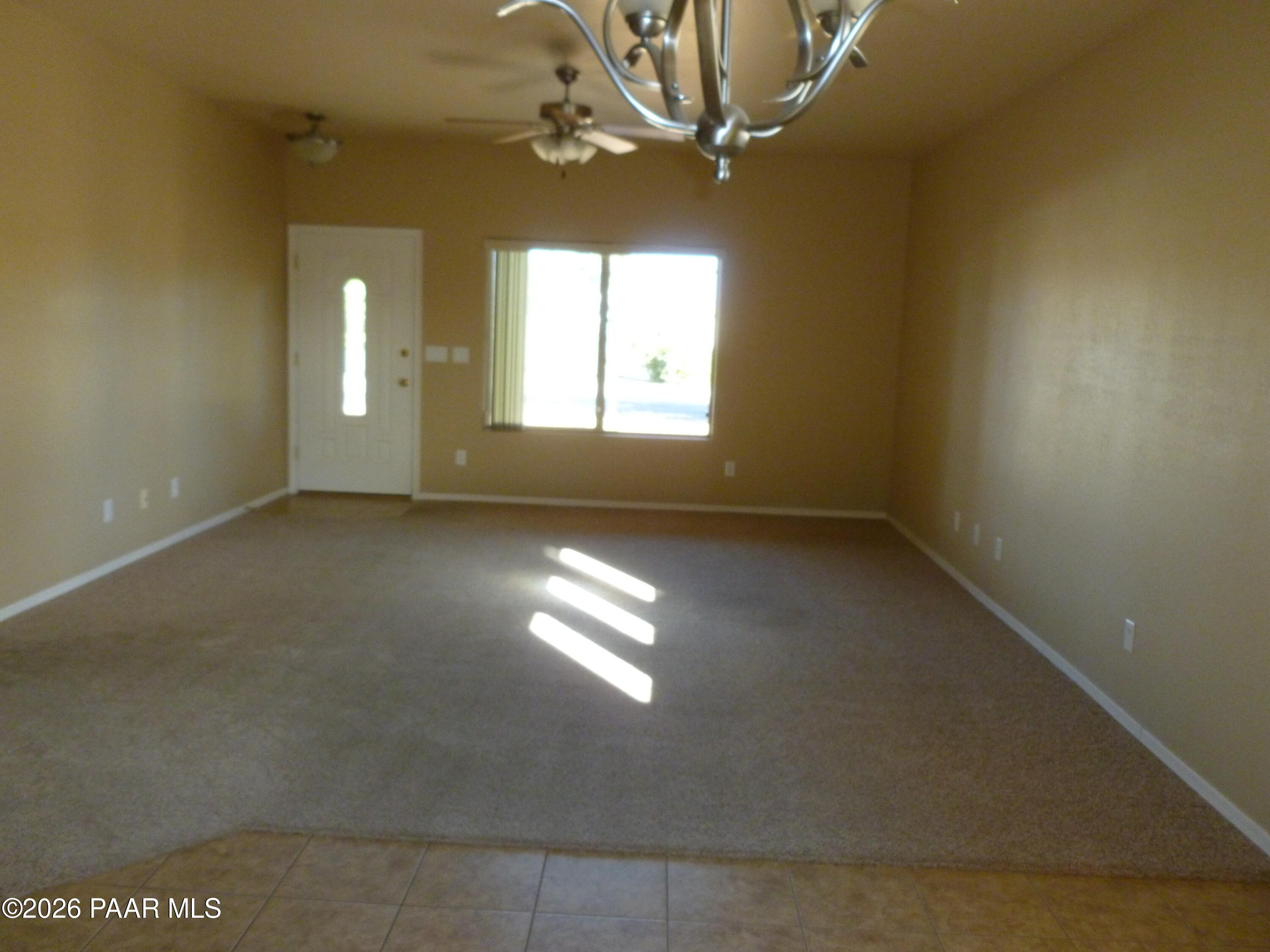 3416 North Victor Road, Unit 1 Prescott Valley, AZ 86314 - Photo 4 of 27 en empty room with windows and chandelier fan