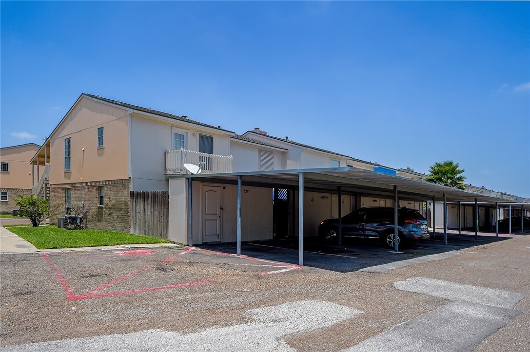 6702 Everhart Road, Unit I105 Corpus Christi, TX 78413 - Photo 19 of 19 a view of a house with a barbeque and large trees