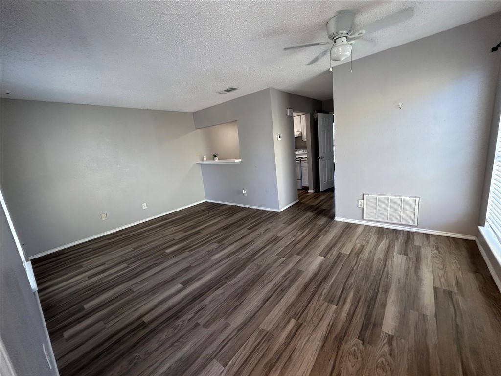 6702 Everhart Road, Unit I105 Corpus Christi, TX 78413 - Photo 4 of 19 wooden floor in an empty room with a window