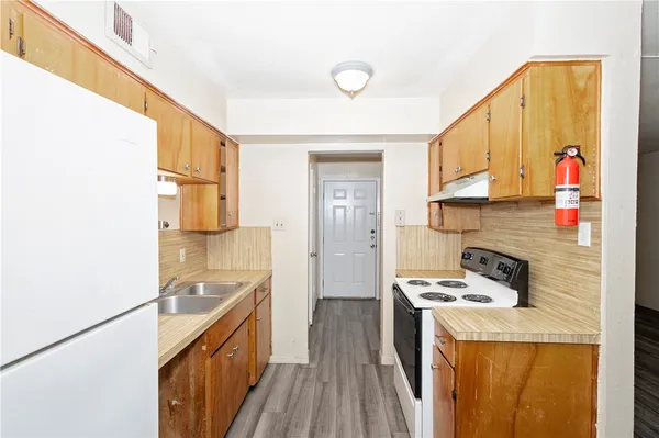 a kitchen with sink refrigerator and stove