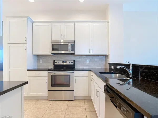 a kitchen with stainless steel appliances a sink stove and cabinets