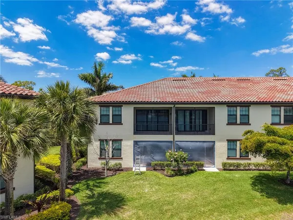 a view of a swimming pool with lawn chairs under an umbrella