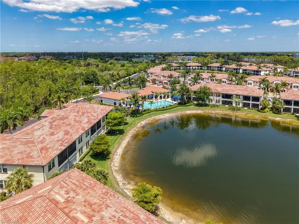 an aerial view of residential houses with outdoor space and lake view