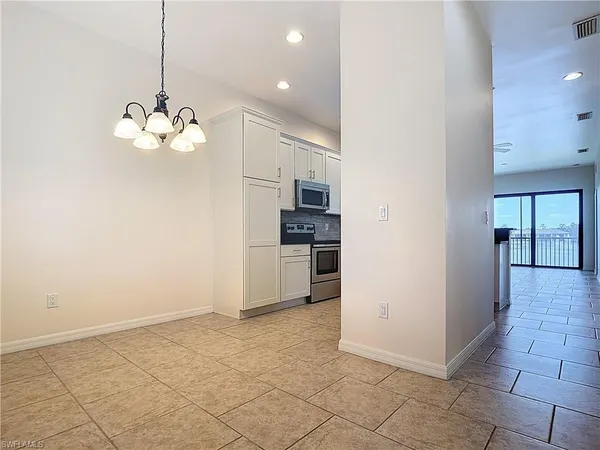 a kitchen with white cabinets and appliances