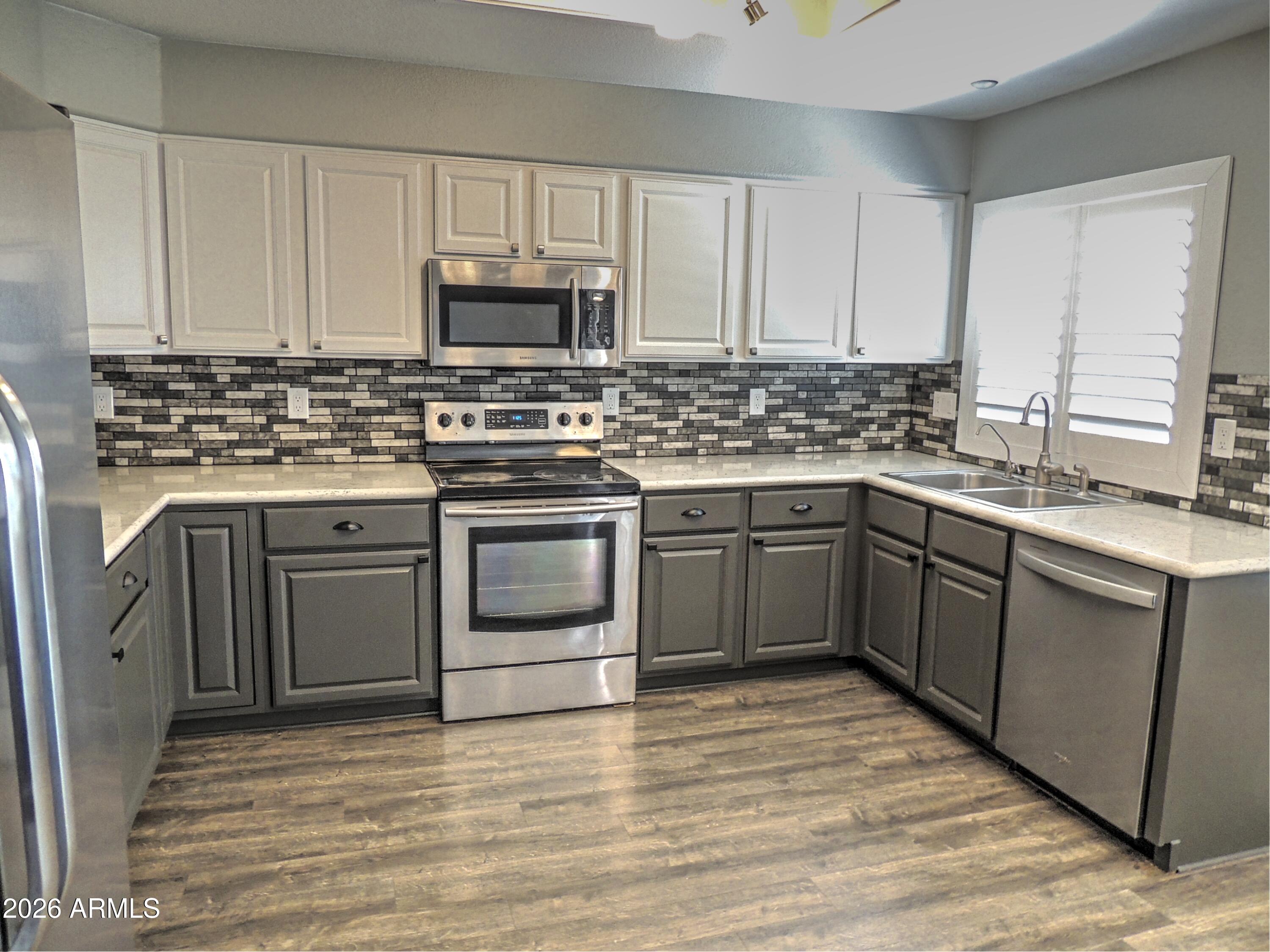 4409 East Dry Creek Road Phoenix, AZ 85044 - Photo 4 of 34 a kitchen with stainless steel appliances granite countertop a stove a sink dishwasher and a refrigerator