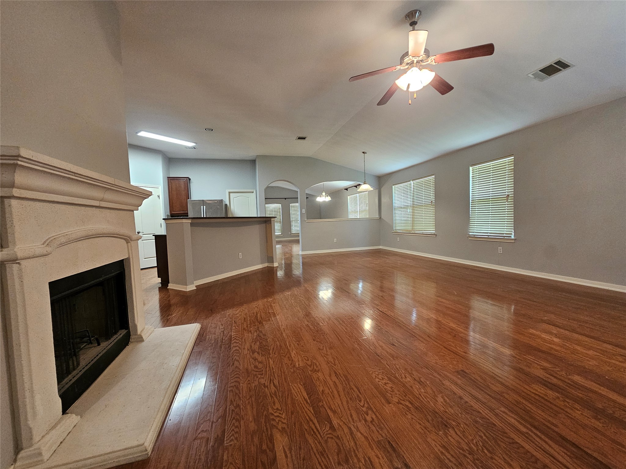 2035 Intrepid Drive Buda, TX 78610 - Photo 4 of 26 Rich hardwood flooring flows through this ample living area, centered by a charming fireplace and brightened by multiple windows.