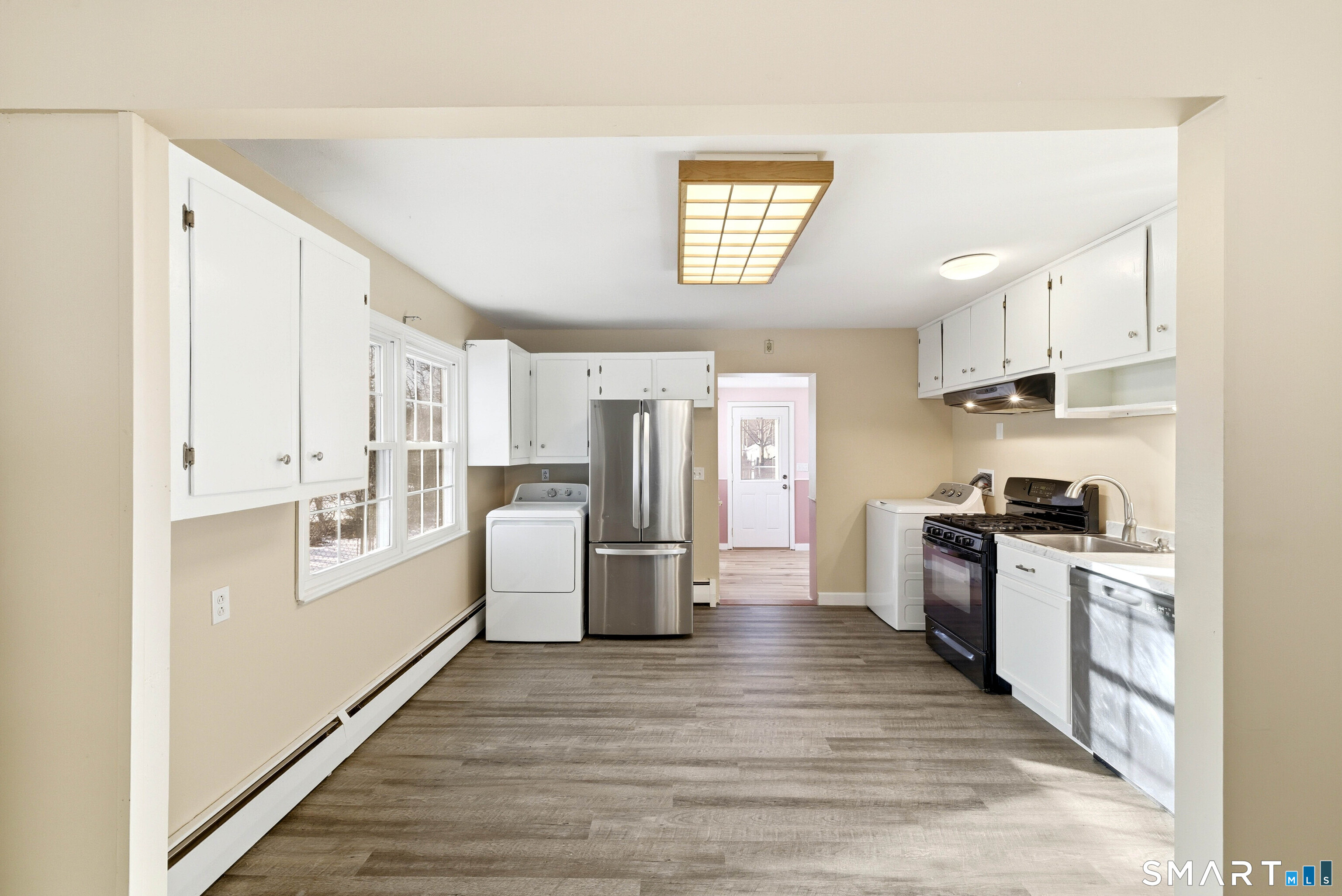 57 Hellstrom Road East Haven, CT 06512 - Photo 11 of 36 a kitchen with stainless steel appliances a stove top oven a refrigerator a sink dishwasher with wooden floor and cabinets
