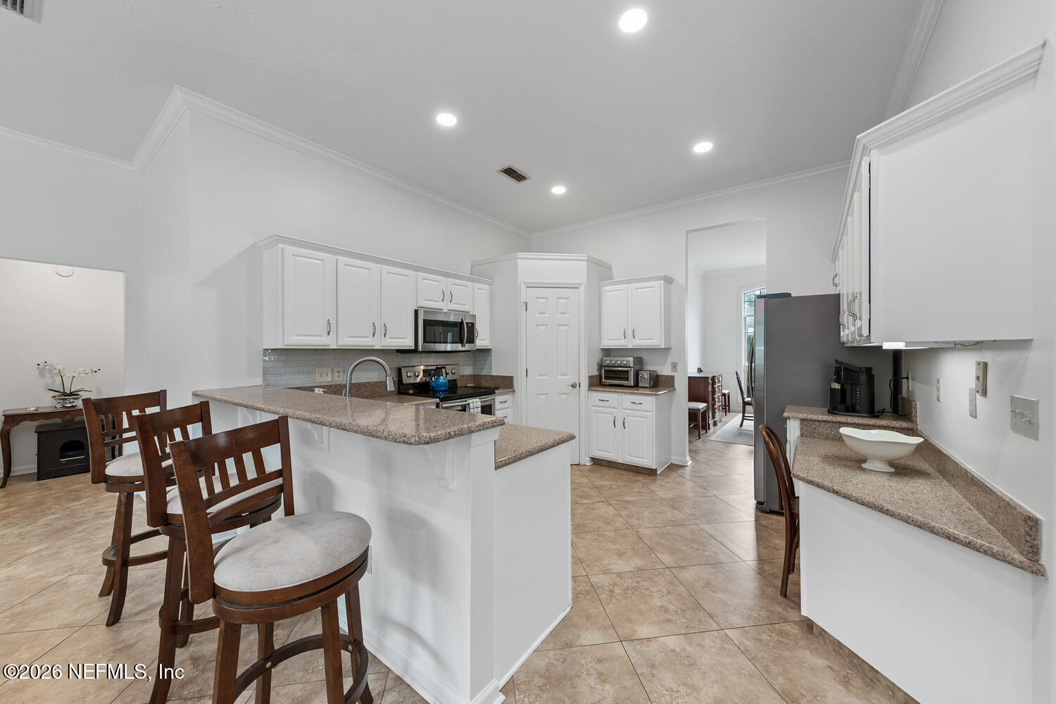 240 Shell Bluff Court Ponte Vedra Beach, FL 32082 - Photo 20 of 53 a kitchen with stainless steel appliances kitchen island granite countertop a table chairs sink and cabinets