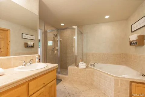 a bathroom with a granite countertop sink a mirror and a bathtub