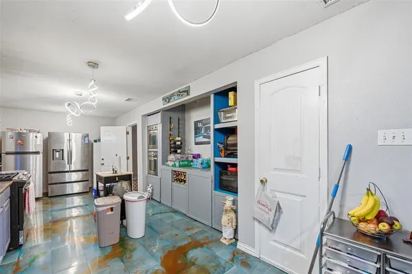 a kitchen with stainless steel appliances wooden floor and a refrigerator