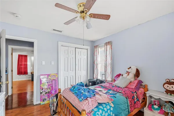 a bedroom with a bed and wooden floor