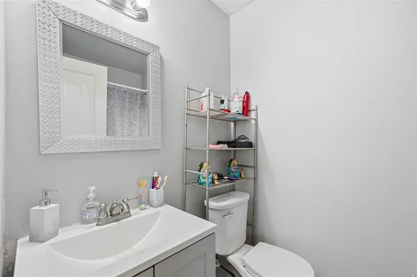 a bathroom with a sink a toilet and a mirror