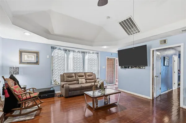 a living room with furniture a flat screen tv and a large window