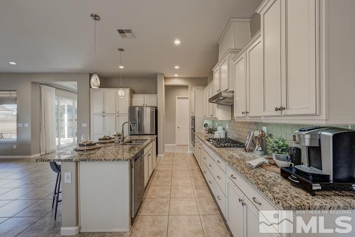 9665 Thesolious Lane Reno, NV 89521 - Photo 7 of 39 a large kitchen with granite countertop a large counter top stainless steel appliances and cabinets