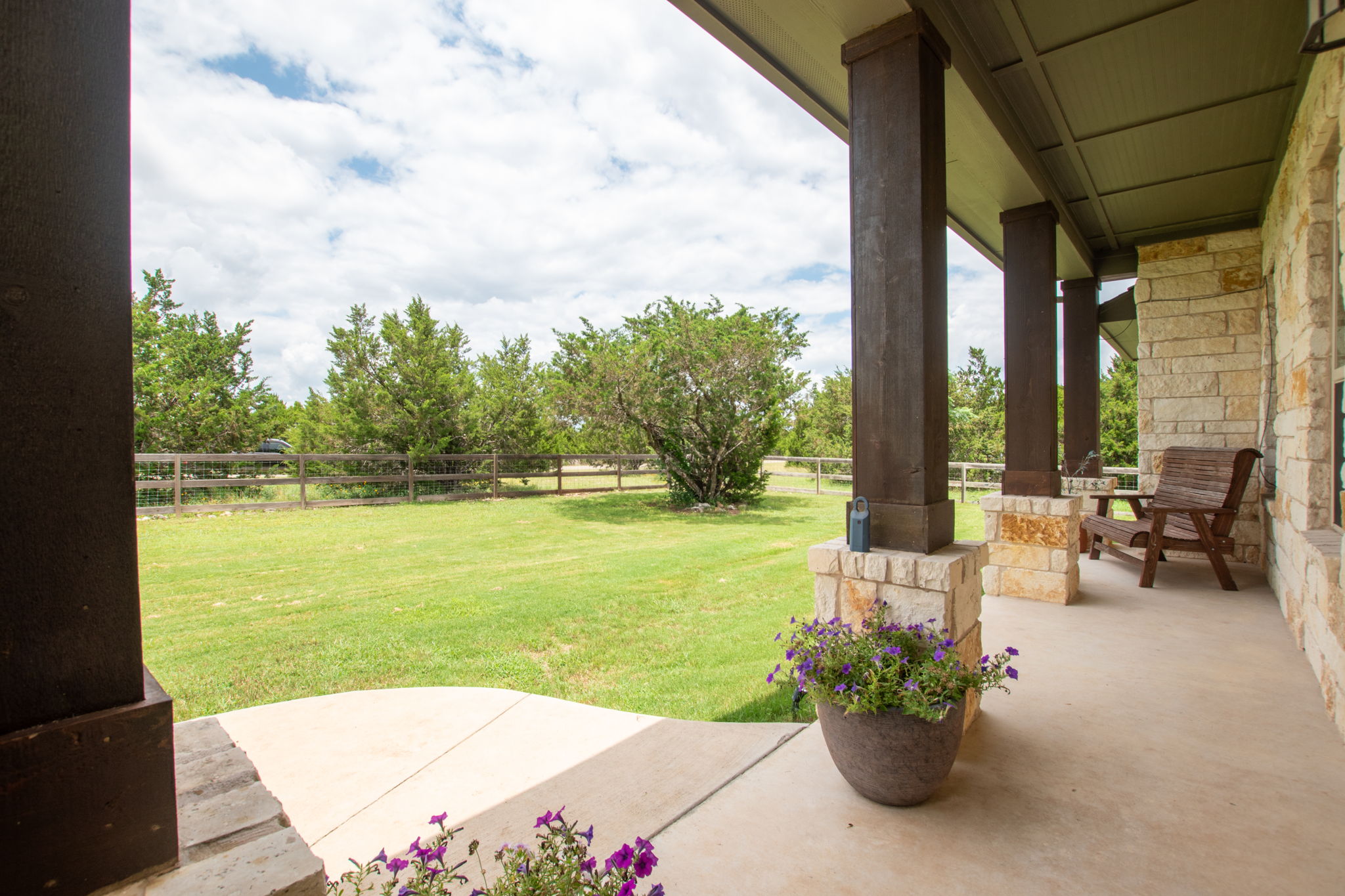 155 Balcones Ridge Way Bertram, TX 78605 - Photo 5 of 37 The spacious and welcoming covered porch offers scenic views of the vast yard and surrounding trees.