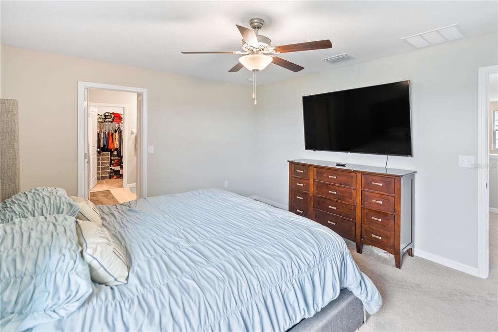 9313 Lemon Drop Loop Ruskin, FL 33573 - Photo 11 of 29 a bedroom with a bed and a flat screen tv