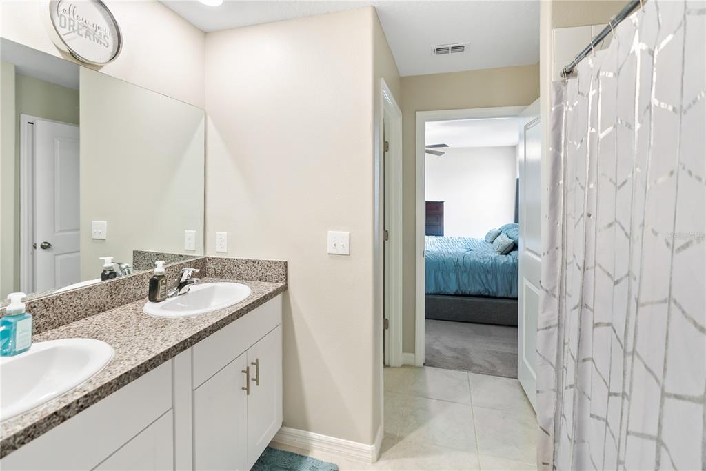 9313 Lemon Drop Loop Ruskin, FL 33573 - Photo 14 of 29 a en suite bathroom with a double vanity sink and a mirror