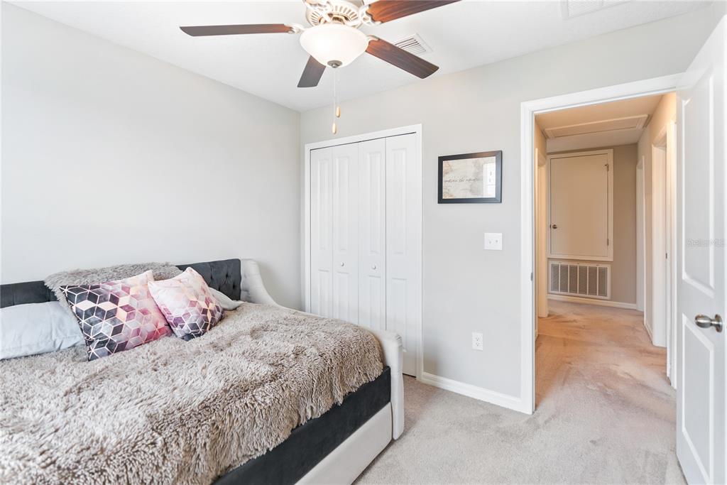 9313 Lemon Drop Loop Ruskin, FL 33573 - Photo 17 of 29 a bedroom with a bed and a chandelier