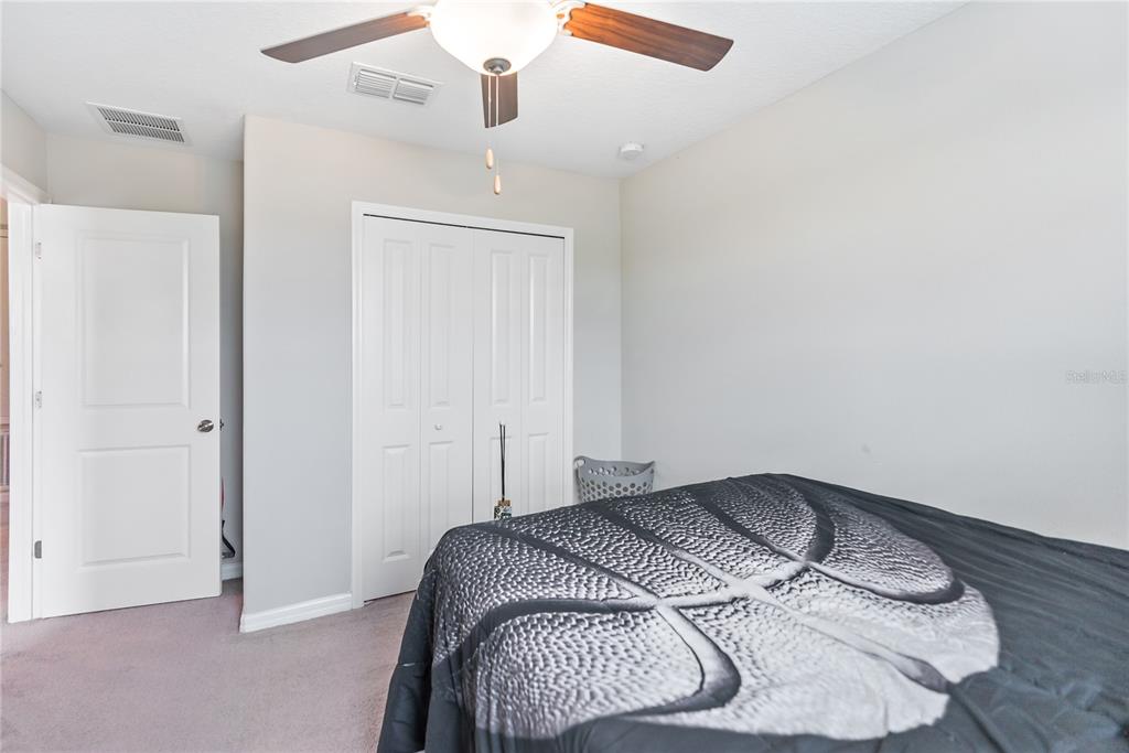 9313 Lemon Drop Loop Ruskin, FL 33573 - Photo 20 of 29 a bedroom with a bed and a ceiling fan