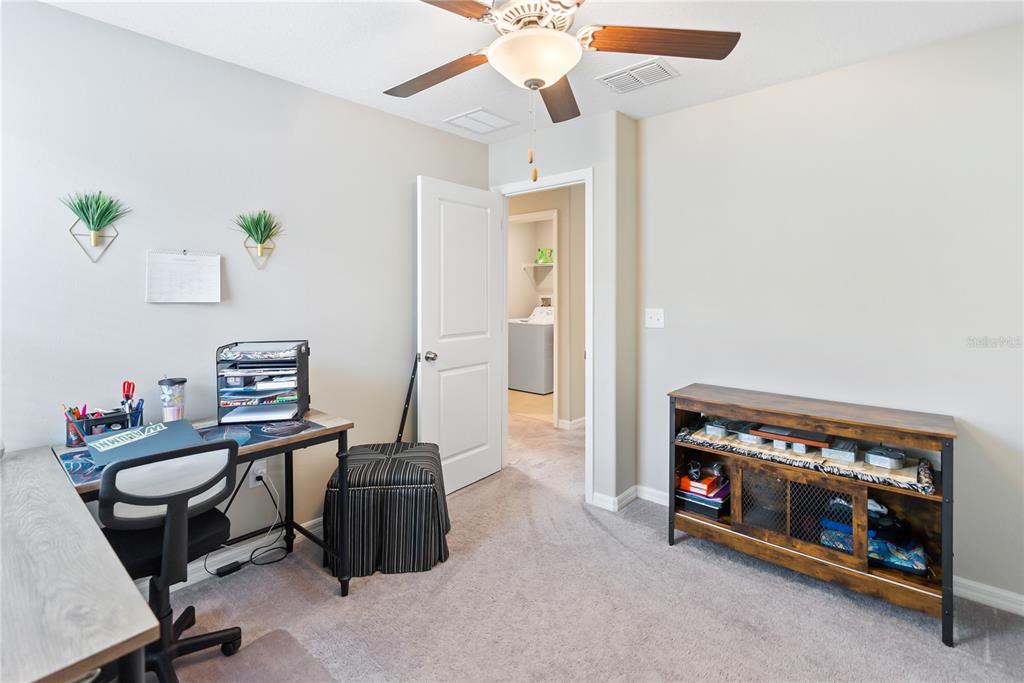 9313 Lemon Drop Loop Ruskin, FL 33573 - Photo 23 of 29 a view of a workspace with furniture and a ceiling fan