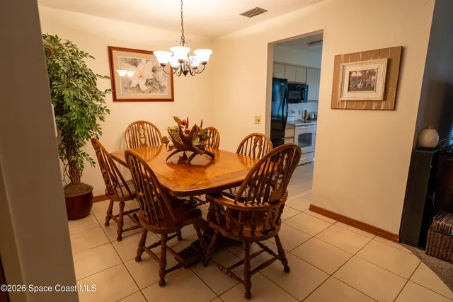 a view of a dining room with furniture and chandelier