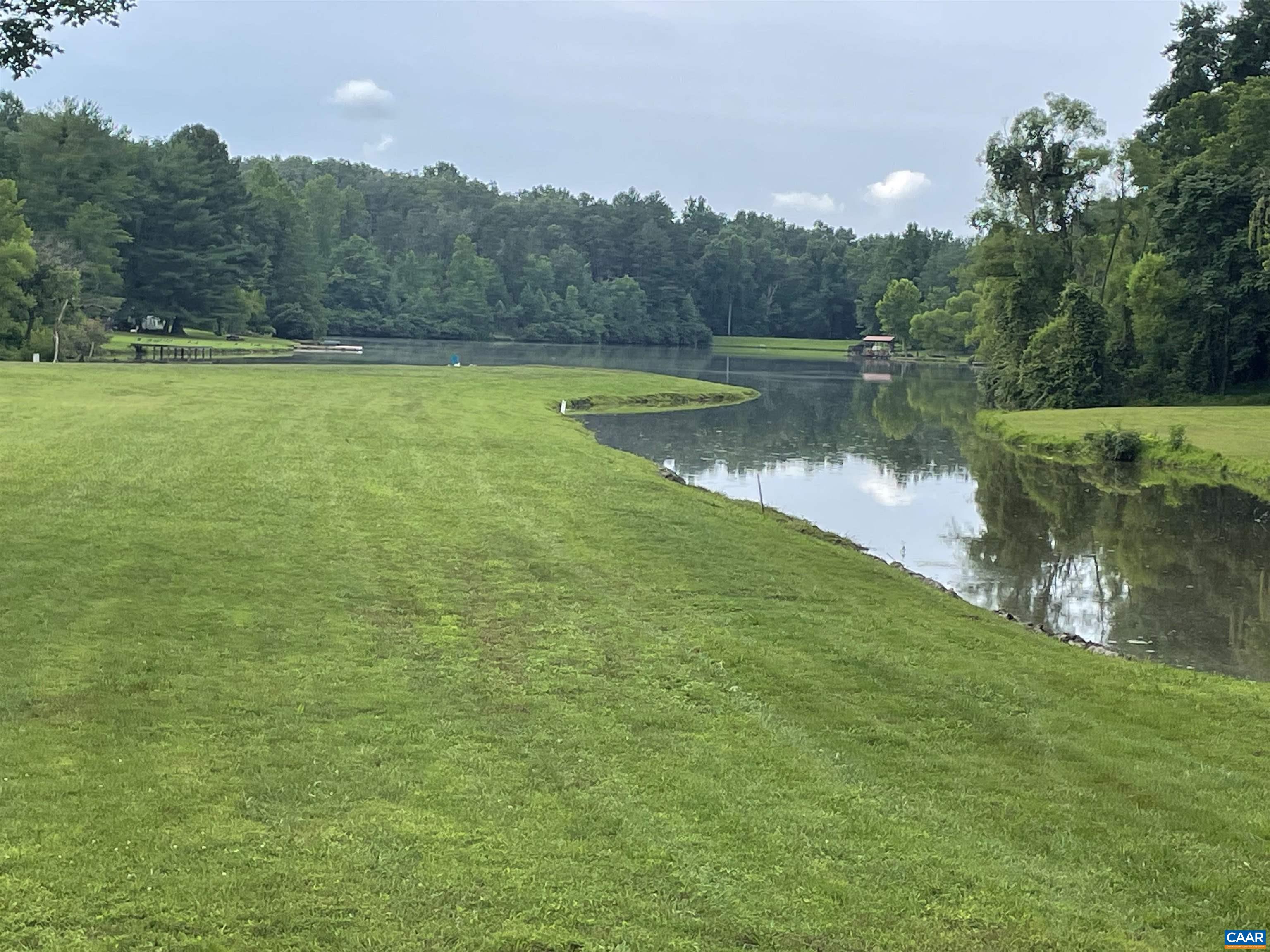 22 Crest Road Ruckersville, VA 22968 - Photo 5 of 6 a view of a lake with a yard and large trees