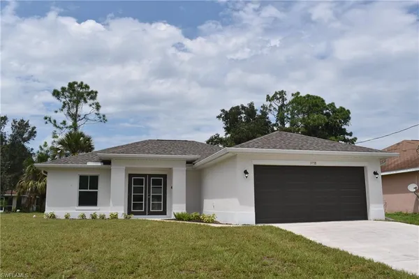 a front view of a house with a garden and yard