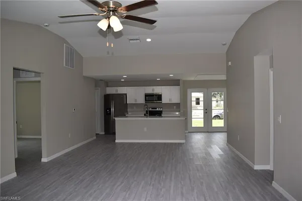 a view of a livingroom with a chandelier fan and wooden floor