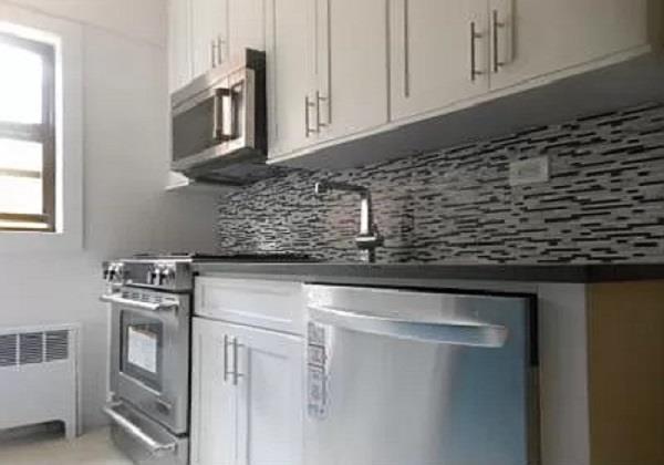 a kitchen with stainless steel appliances granite countertop white cabinets and stove