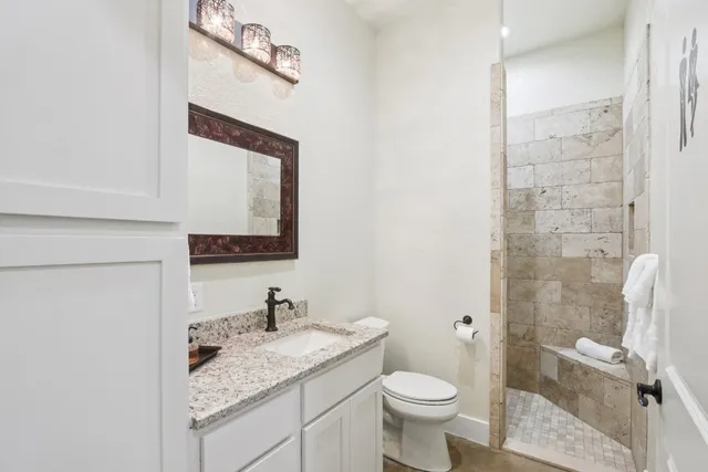 a bathroom with a granite countertop sink toilet and shower