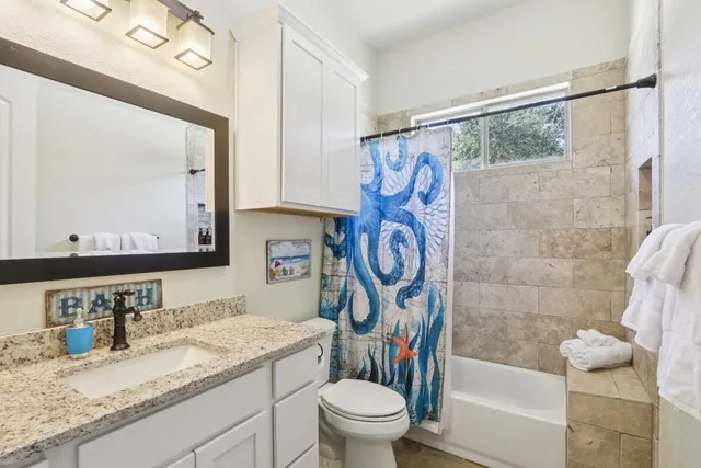 a bathroom with a granite countertop sink mirror toilet and shower