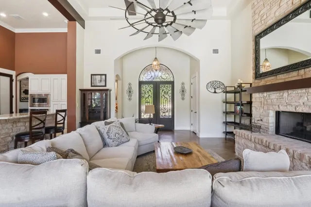 a living room with furniture a fireplace and a chandelier