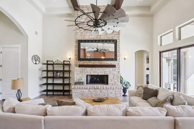 a living room with furniture a fireplace and a chandelier