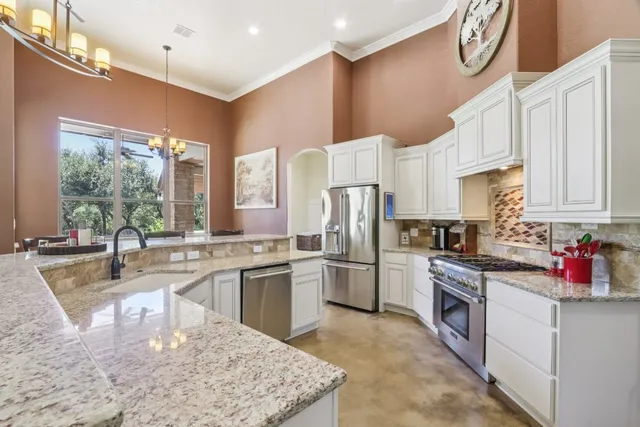 a kitchen with stainless steel appliances granite countertop a sink stove and refrigerator