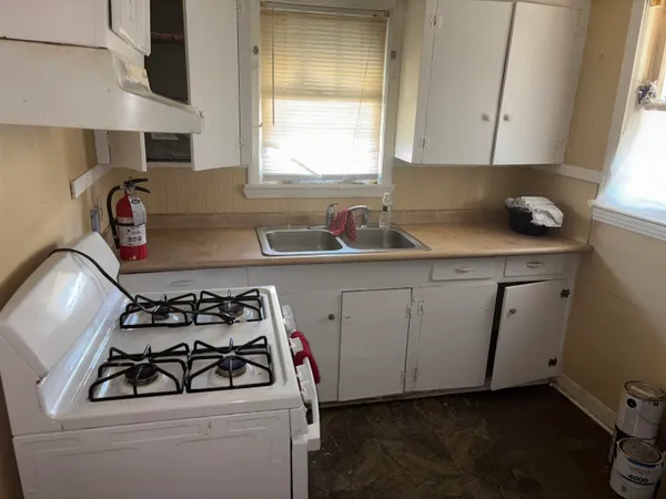 a kitchen with sink a stove and cabinets