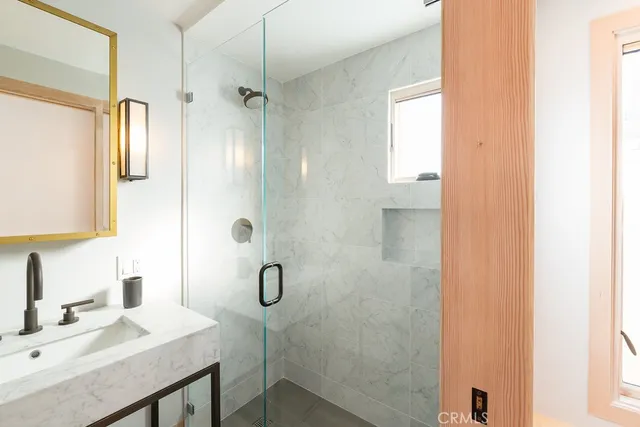 a bathroom with a shower sink and mirror