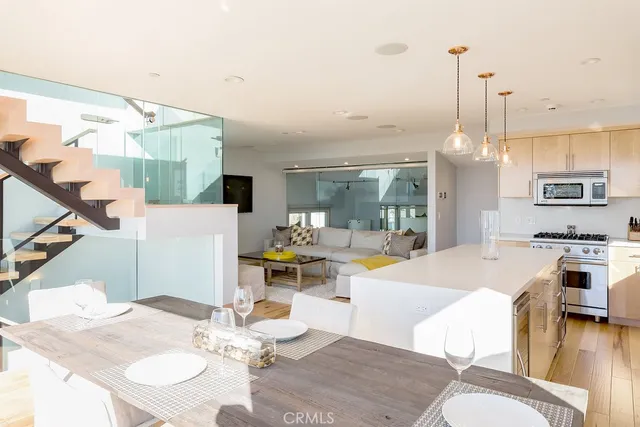 a dining room with wooden floor a chandelier a wooden table and chairs