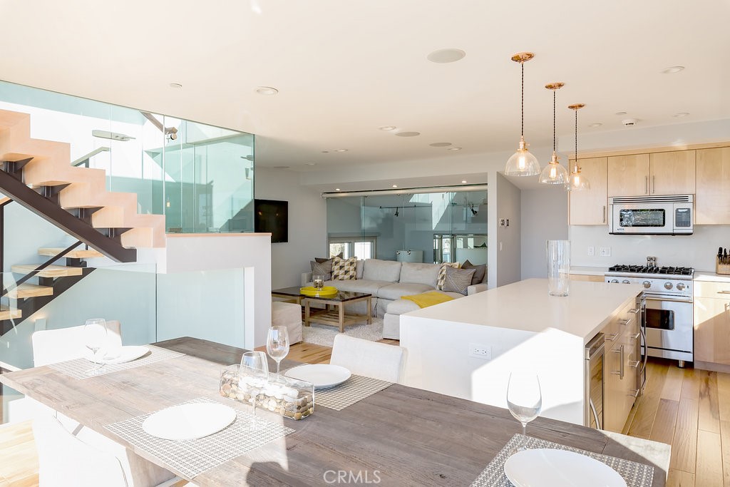 814 Monterey Boulevard Hermosa Beach, CA 90254 - Photo 5 of 28 a dining room with wooden floor a chandelier a wooden table and chairs