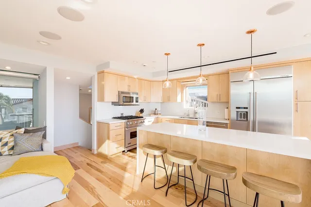 a large kitchen with kitchen island a large window and stainless steel appliances