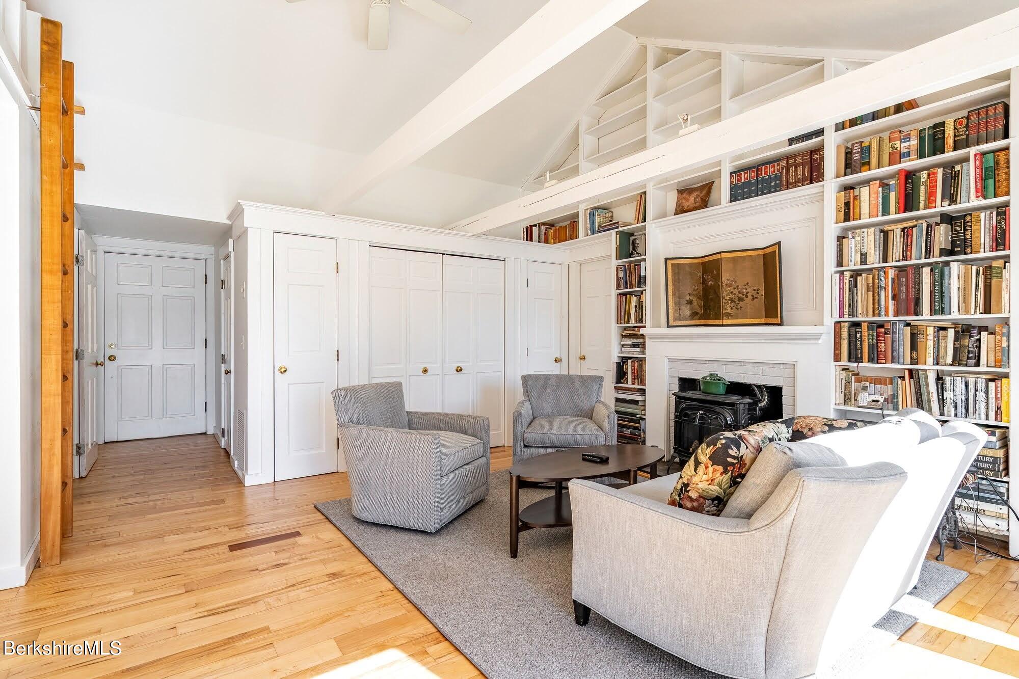 7 Point Road Monterey, MA 01245 - Photo 17 of 41 a living room with furniture a fireplace and a book shelf