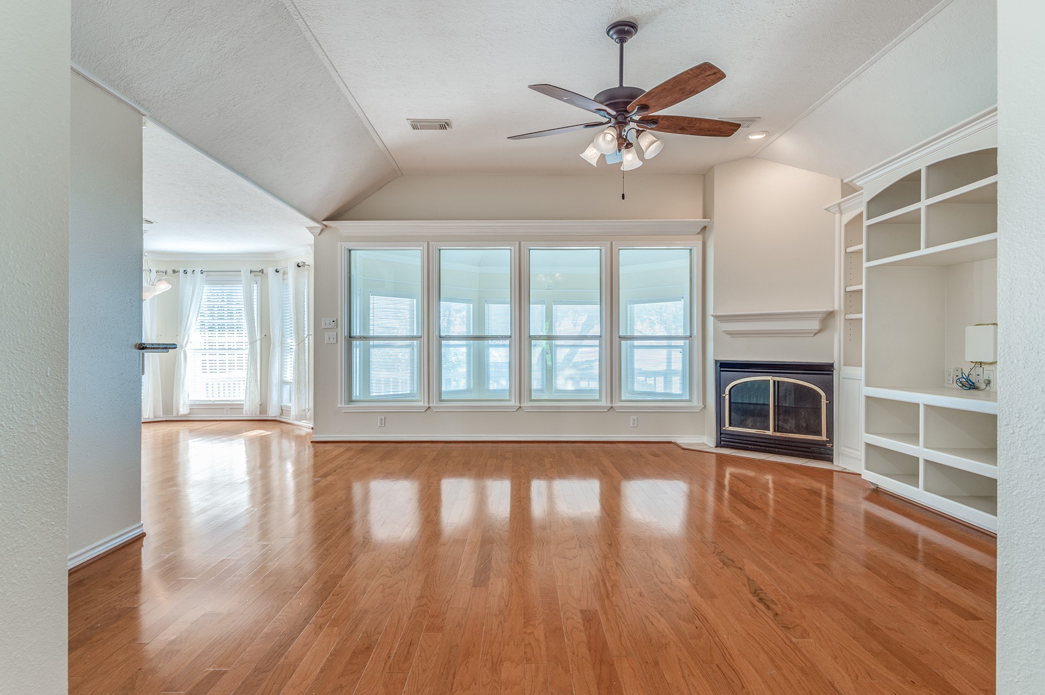 341 Sam Houston Loop Point Blank, TX 77364 - Photo 7 of 36 wooden floor fireplace and windows in an empty room