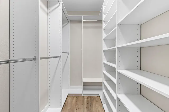 a view of walk in closet with empty racks