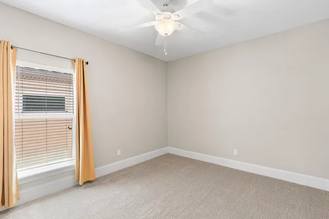 a view of a room with a ceiling fan and a window