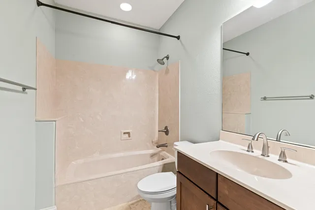 a bathroom with a granite countertop sink toilet and shower