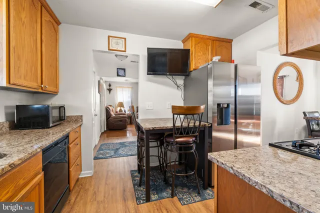 a kitchen with stainless steel appliances granite countertop a sink a stove and a wooden floors