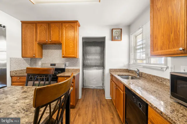 a kitchen with stainless steel appliances granite countertop wooden cabinets a stove top oven a sink and dishwasher