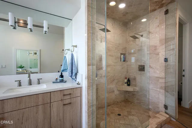 a bathroom with a shower sink and mirror