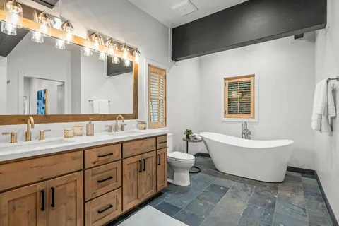 a spacious bathroom with a double vanity sink mirror and bathtub