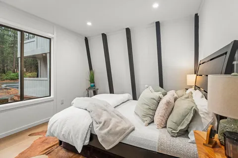 a bedroom with a bed and a large window