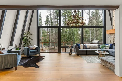 a living room with furniture and floor to ceiling windows
